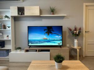 a living room with a flat screen tv on a wall at Beach Apartment, Torre Benagalbón in Torre de Benagalbón