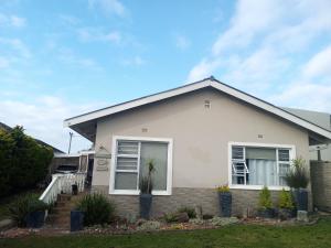 ein weißes Haus mit Pflanzen im Vorgarten in der Unterkunft 94 on Main in Kiddʼs Beach