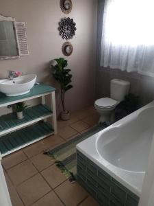 ein Badezimmer mit Waschbecken, Badewanne und Toilette in der Unterkunft 94 on Main in Kiddʼs Beach + 7 Fotos
