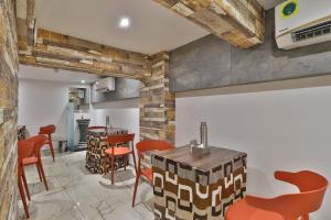 a dining room with orange chairs and a table at Hotel Legend in Surat