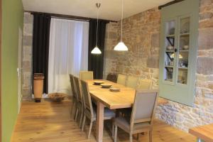 a dining room with a wooden table and chairs at La Min-sú de Terrasson in Terrasson-Lavilledieu