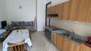 a small kitchen with a table and a sink and a couch at Vititta Appartamenti in Trapani