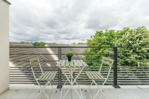 a balcony with a table and chairs on a roof at OVELIA Herblay - L'Orée des Ormes in Herblay