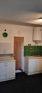 a kitchen with a door with a clock on the wall at G&G Vacation Home in Cîlnic