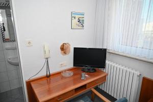 a television on a wooden desk in a room at Einzelzimmer-01-EG in Borkum