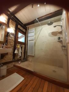 a bathroom with a glass shower in a room at Chambre à la Ferme BANZAÏ - Face aux Pyrénées AURIGNAC in Aurignac