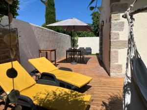メーズにあるPetite maison individuelle proche plageのパティオ(黄色のラウンジチェア2脚、パラソル1本付)