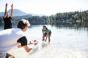 a group of people playing in the water on a lake at Explorer Hotel Stubaital in Neustift im Stubaital