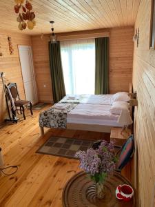 a bedroom with a bed in a wooden room at HOMELAND in Mestia