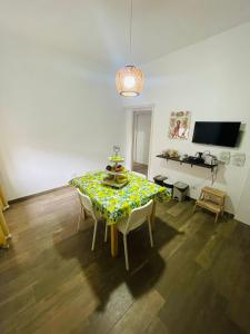 a dining room with a table and chairs and a television at Casa Politeama Spacious Central Flat by Oplonti Station for Pompeii, Sorrento and Naples in Torre Annunziata