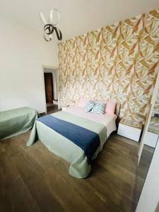 a bedroom with a bed with a wall at Casa Politeama Spacious Central Flat by Oplonti Station for Pompeii, Sorrento and Naples in Torre Annunziata