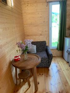 a room with a table with a couch and flowers on it at HOMELAND in Mestia +13 photos