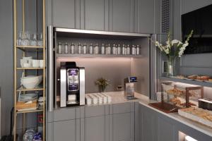 a kitchen with a drink dispenser in a cabinet at Astra Hotel in Ferrara