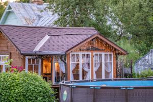 a small house with a tiled roof and a pool at Strazdu Māja in Jūrmala +21 photos