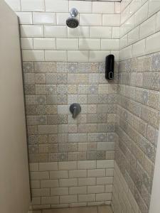 ein Bad mit einer Dusche und weißen Fliesen in der Unterkunft Antique Hostel in Bukarest + 51 Fotos