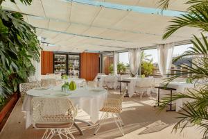 a restaurant with white tables and chairs and plants at Claris Hotel & Spa GL, a Small Luxury Hotel of the World in Barcelona