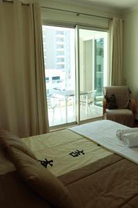 a bedroom with a large bed and a balcony at GuestReady - Rodamar Apartment in Ilhéu do Gorgulho