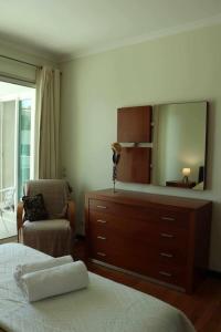 a bedroom with a dresser and a mirror at GuestReady - Rodamar Apartment in Ilhéu do Gorgulho