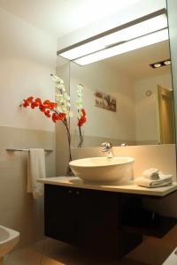 a bathroom with a sink and a large mirror at GuestReady - Rodamar Apartment in Ilhéu do Gorgulho