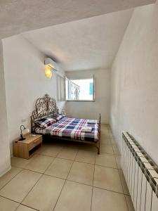 a small bedroom with a bed and a window at Appartamenti Dépendance Mariel in Orbetello