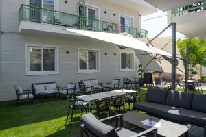 an outdoor patio with tables and chairs and an umbrella at Olive Boutique Hotel in Limenaria