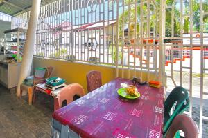 a purple table with a plate of food on it at Amira House Kisaran RedPartner in Kisaran