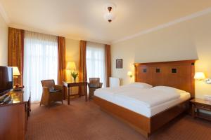a hotel room with a large bed and a television at Vju Hotel Rügen in Göhren