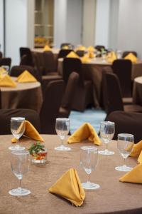 a table with yellow napkins and wine glasses on it at Unisi Hotel Malioboro - Jogja Syariah in Yogyakarta