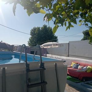 a pool with a table and an umbrella next to a couch at O Refúgio do Pastor in Sousel