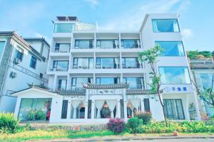 大理大理子鱼居树果海景酒店(圣托里尼店)的一栋白色建筑和一栋中国建筑