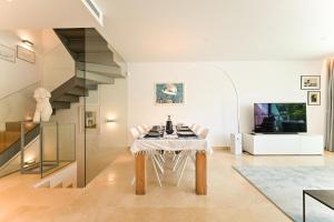 Un comedor con mesa y sillas y una escalera. en La Valvega 47, en Mijas Costa