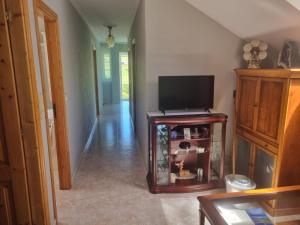 sala de estar con mesa y TV en Casa Saburil, en Nemiña