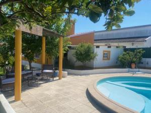 a large swimming pool in a yard with a building at Casa Almenara in Quinta do Anjo