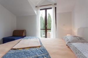 Un dormitorio con una cama y una silla y una ventana. en Villa Anka 2, en Cavtat