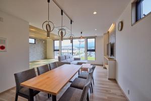 a dining room and living room with a table and chairs at Miire Mt Fuji Natural in Fujikawaguchiko