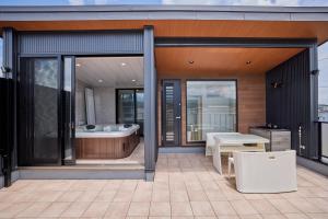 a bathroom with a tub and a table on a balcony at Miire Mt Fuji Natural in Fujikawaguchiko