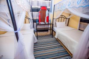 ダル・エス・サラームにあるKAYS LODGEのベッドルーム1室(ベッド2台、天蓋付)