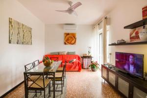 a living room with a table and a red couch at Chiwi's Home in Vado Ligure