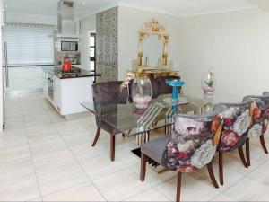 a dining room with a glass table and chairs at The Villa @ Balugha River Estate in Glengariff