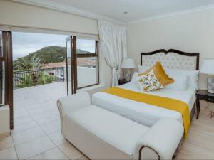 a bedroom with a large bed and a balcony at The Villa @ Balugha River Estate in Glengariff