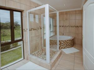 a bathroom with a tub and a large window at The Villa @ Balugha River Estate in Glengariff +19 photos