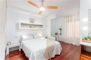 een witte slaapkamer met een bed en een plafondventilator bij BAY VIEW in Altea +25 foto's