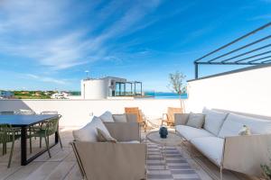 a patio with a couch and a table and chairs at Beachfront Villa Taris with Seaview in Privlaka