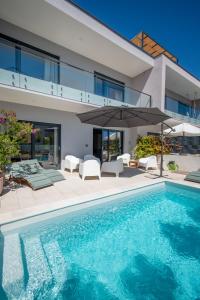 a villa with a swimming pool and a house at Beachfront Villa Taris with Seaview in Privlaka