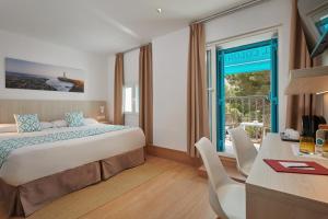 pokój hotelowy z łóżkiem, biurkiem i oknem w obiekcie Hotel Colonial w miejscowości Colonia Sant Jordi