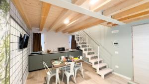 Una habitación con una mesa y sillas y una escalera. en Graceful Apartments Paradise by Ca-Sa Check, en Chioggia