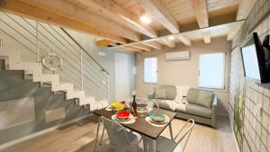 Habitación con mesa, sofá y escaleras en Graceful Apartments Paradise by Ca-Sa Check, en Chioggia 26 fotos más