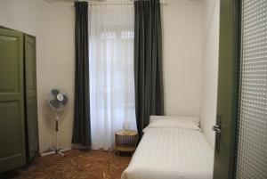 a bedroom with a bed and a window with a fan at Nenè Pescatori Room in Bellagio