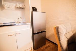 a kitchen with a stainless steel refrigerator and a chair at Hotel Amaranth Kyoto Gojo - Vacation STAY 19876v in Kyoto
