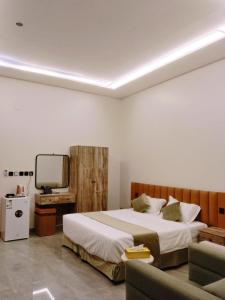 a bedroom with a bed and a tv and a couch at شقق كالم للشقق المخدومة 1 in Riyadh +23 photos